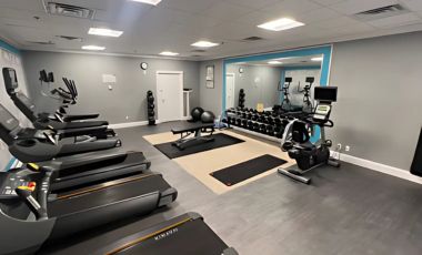 A fitness center with various exercise equipment in a Crowne Plaza Orlando Downtown hotel near the Cure Bowl in Orlando.