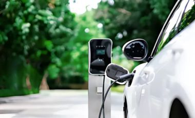 An electric car charging at a station outside Crowne Plaza Orlando Downtown, showcasing sustainable transportation.