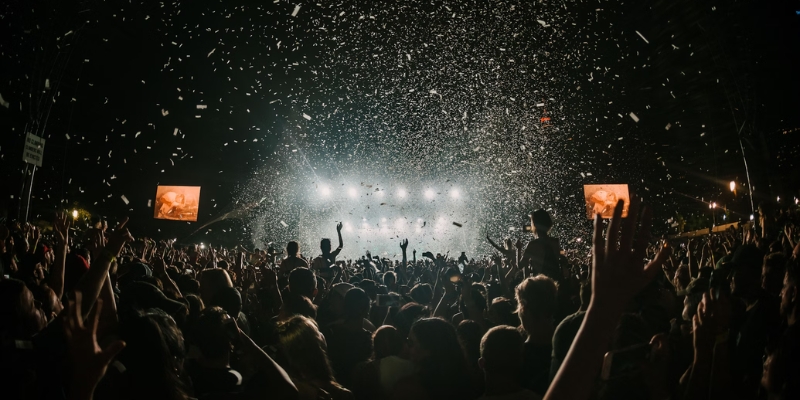 A lively concert crowd with people joyfully raising their hands, celebrating an event in downtown Orlando.