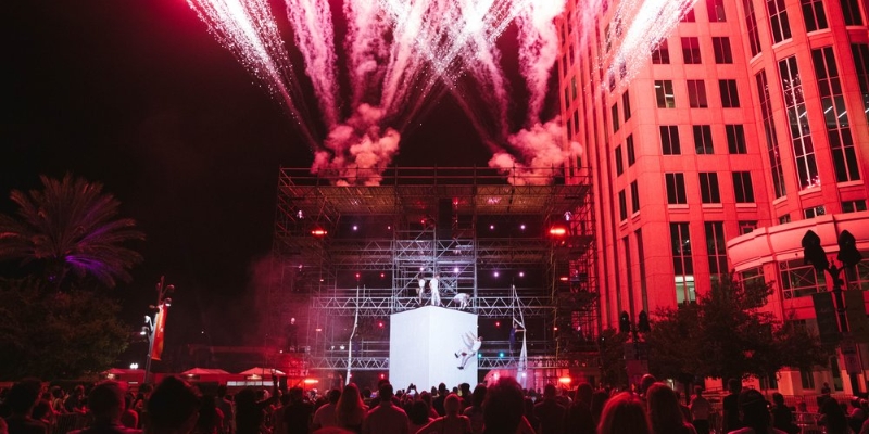 A vibrant display of fireworks bursts above an enthusiastic crowd during the Immerse Art Festival in Downtown Orlando.