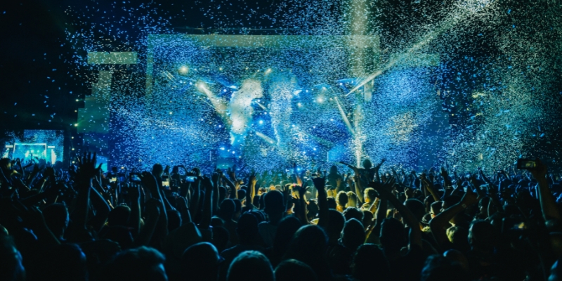A bustling crowd at a concert, joyfully immersed in the moment as confetti cascades around them at KIA Center in Downtown Orlando.