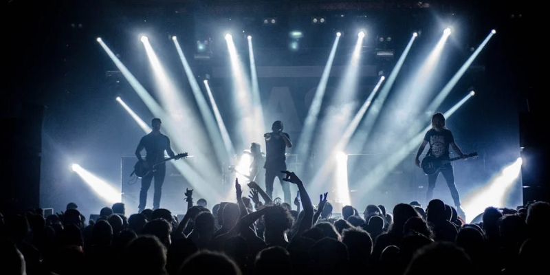 A lively band on stage illuminated by bright lights, capturing the energetic vibe of Downtown Orlando's Milk District.