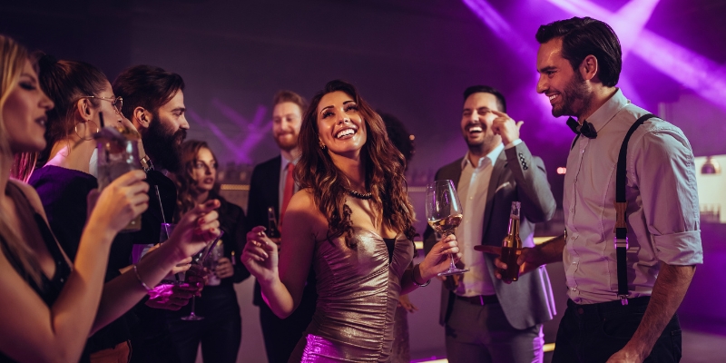 A cheerful group of adults celebrating with drinks at a party, representing the nightlife options in Downtown Orlando.