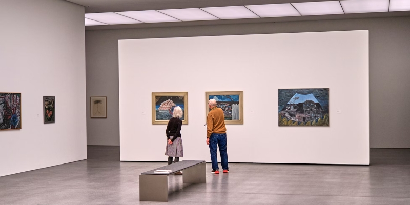 Two individuals observe artwork in an art museum, enjoying a cultural experience in downtown Orlando.