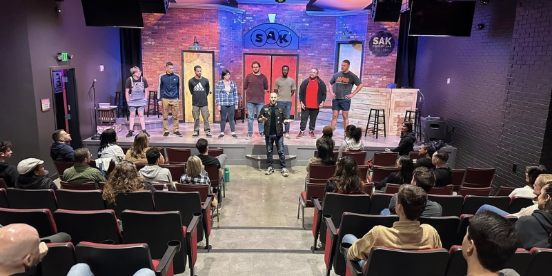 A diverse audience seated in a theater, engaged in a live performance at SAK Comedy Lab in Downtown Orlando.