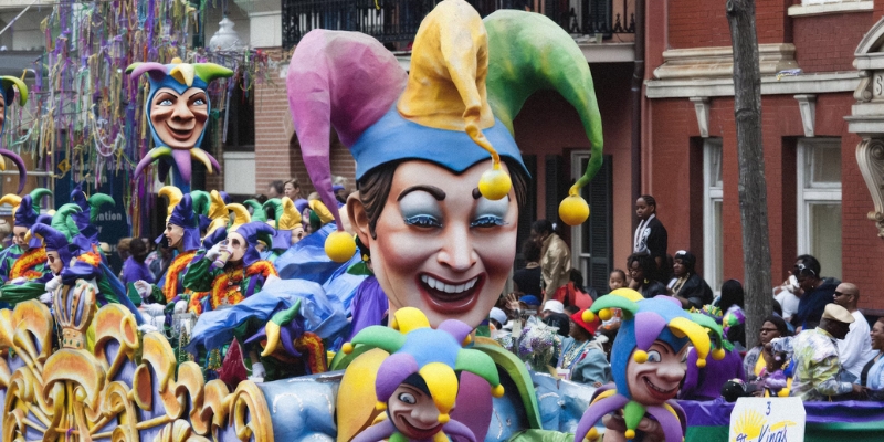 A festive parade float showcasing a clown face, highlighting the Mardi Gras celebration at Universal Studios Florida in downtown Orlando.