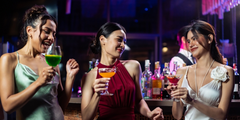 At Aero Rooftop Bar & Lounge, three women enjoy drinks together, celebrating a bachelorette party in Orlando.
