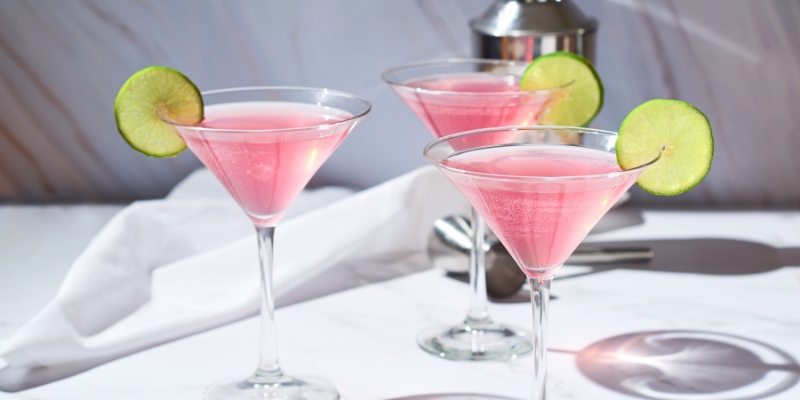 Three pink cocktails with lime slices on a marble counter, set for an Orlando bachelorette party at ICEBAR.