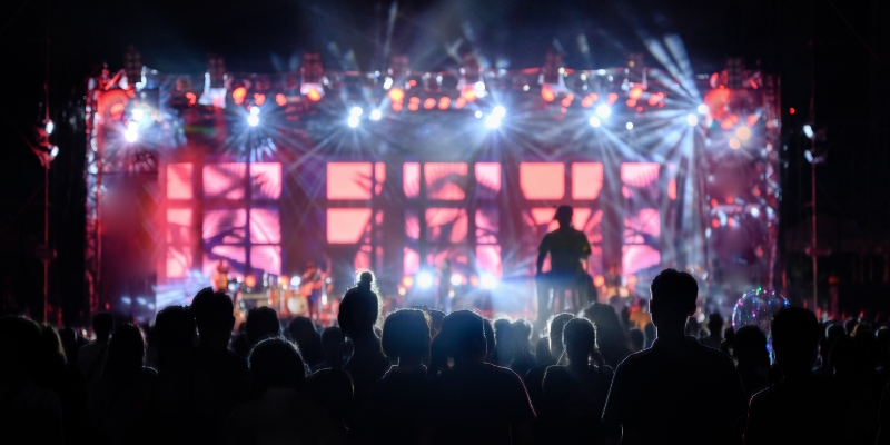 A lively concert scene with a crowd illuminated by bright lights, showcasing the energetic nightlife of an Orlando bachelorette party.