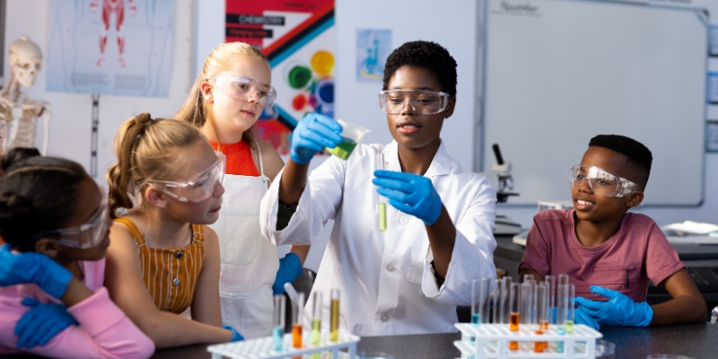 A group of children wearing lab coats and gloves, engaged in a science activity at the Orlando Science Center.