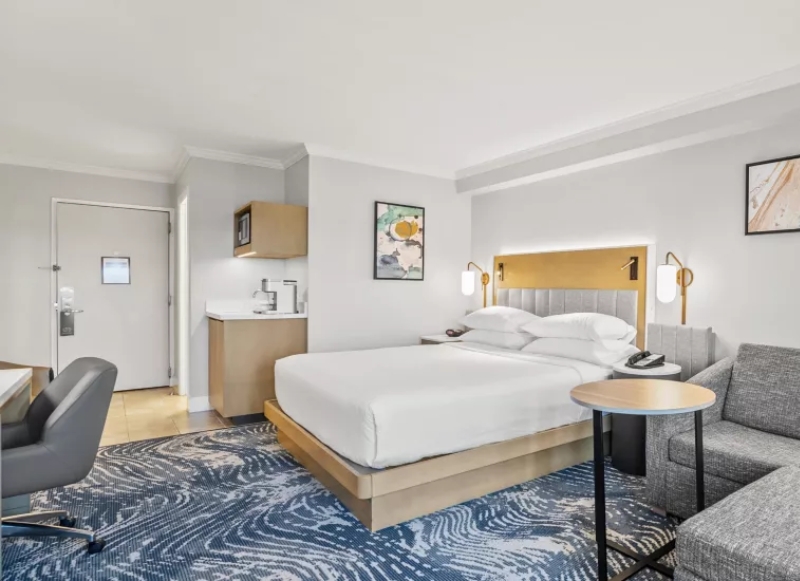 Comfortable hotel room with a bed, desk, and chair, situated at Crowne Plaza Orlando Downtown near the Orlando Convention Center.