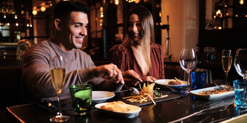 A couple enjoys a meal together in a cozy restaurant, highlighting a romantic dining experience in Orlando, Florida.
