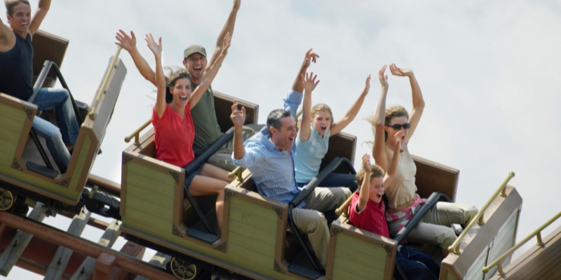 A group of excited people enjoying a thrilling ride on a roller coaster in Orlando, Florida, perfect for family vacations.