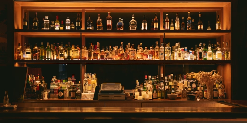 An array of alcohol bottles neatly arranged on shelves in a bar, illustrating the lively nightlife of Orlando, Florida.