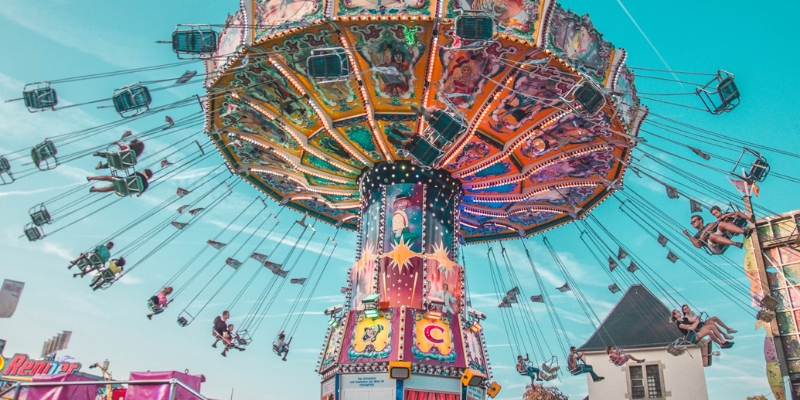 Colorful carnival ride featuring people enjoying the experience, highlighting Orlando's lively theme park atmosphere.