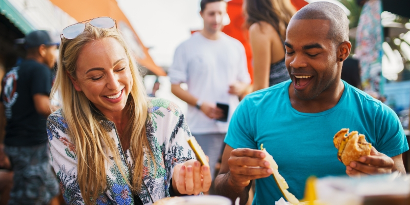 A man and woman enjoy a meal together at a restaurant during the Epcot International Food & Wine Festival in Orlando.