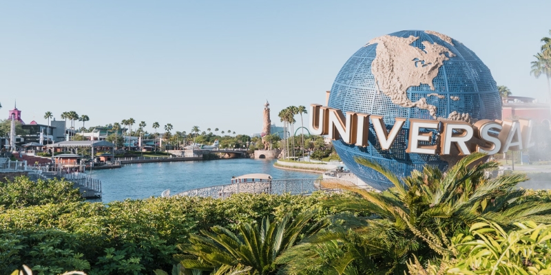 A panoramic scene of Universal Orlando's new City Center, showcasing visitors enjoying the theme park during August.