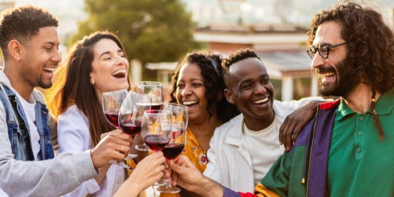 A group of people joyfully toasting with wine glasses at the Busch Gardens Food & Wine Festival in Orlando, April.