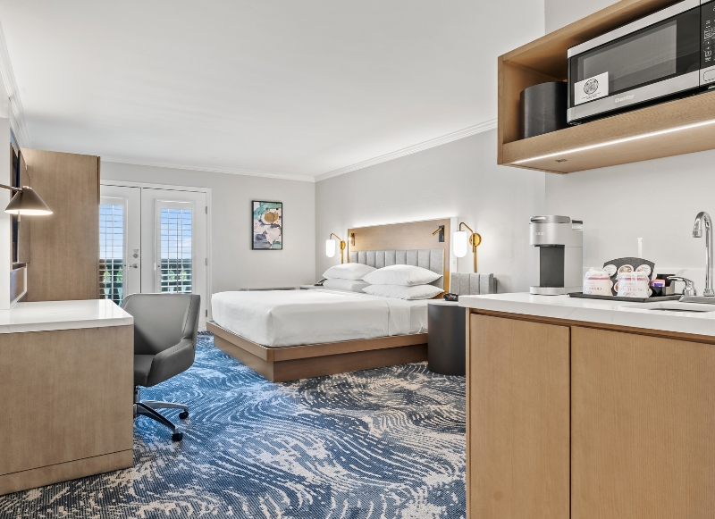 Cozy hotel room with a bed, desk, and microwave, situated close to Winnie Palmer Hospital in Orlando.