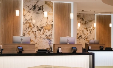 Hotel lobby featuring elegant marble walls and a reception counter, promoting flexible medical stay rates near Winnie Palmer Hospital.