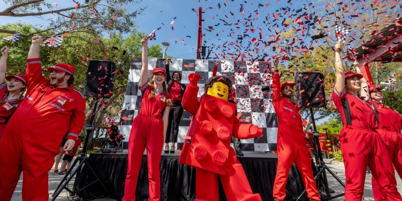 A stage with a group of individuals in red attire, part of the 4th of July festivities at Legoland Florida, Orlando.