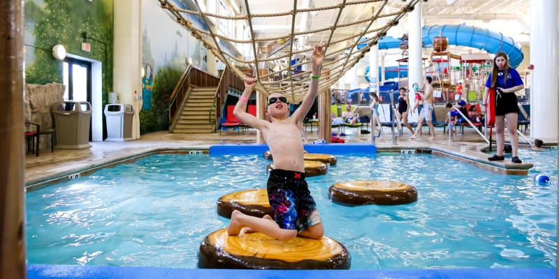 A boy is on a raft in a lively water park, embodying the excitement of summer holidays in Orlando.