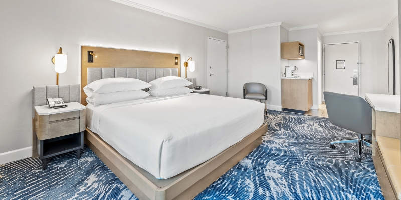 Hotel room featuring a bed, desk, and chair, located near the Orlando Convention Center at Crowne Plaza Orlando Downtown.