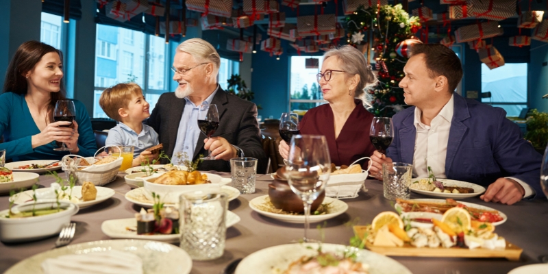 A joyful family enjoying a holiday meal together at a table, showcasing the festive spirit of Christmas in downtown Orlando.