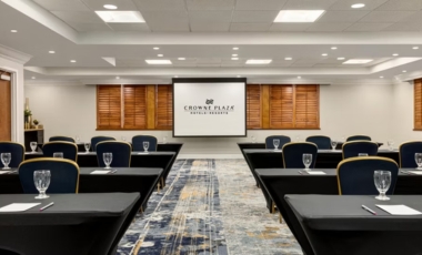 Conference room featuring black chairs and a projector screen, located in a downtown Orlando hotel near Amway Arena.