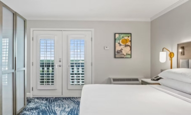 Hotel room featuring a bed, television, and door, located in downtown Orlando near Lake Eola.