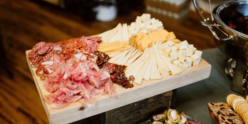 A beautifully arranged table featuring cheese, meats, and crackers, highlighting the unique dining experience at Mango's, Orlando.