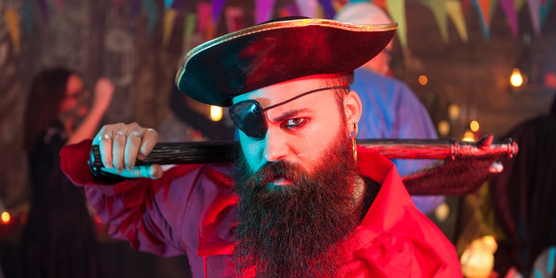 A bearded man wearing a pirate hat, representing the theme of Pirates Dinner Adventure in Orlando.