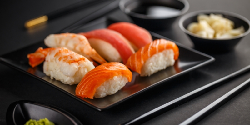 Sushi featuring salmon and avocado on rice, presented on a black background, highlighting Soseki Modern Omakase in Orlando.